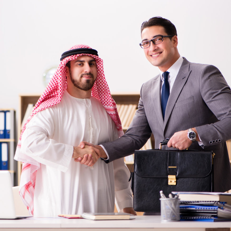 Ein arabischer und ein europäischer Geschäftspartner schließen gemeinsam ein Geschäft ab